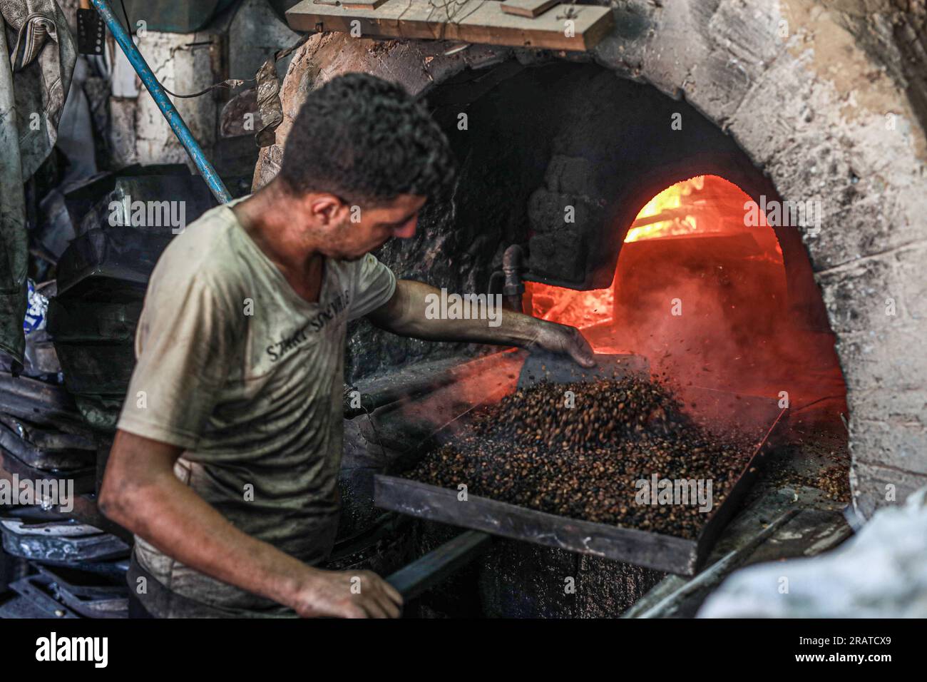 Na'im Sharab, ein 70-jähriger Palästinenser, besitzt den ältesten primitiven Ofen, der vor 130 Jahren von seinen Vorfahren geerbt wurde. Er, seine Kinder und Enkel arbeiten im Ofen der Stadt Gaza. Sharab sagt, dass sie jeden Morgen daran arbeiten, den Ofen vorzubereiten, der mit Holz und verbranntem Öl betrieben wird, das in Geschäften gekauft wurde, die Öle für Autos ersetzen. Mit der Strom- und Gaskrise haben sich einige Menschen daran gewöhnt, Brot, Kaffee und Töpfe in den Ofen zu schicken, wo der größte Anteil an Kochtöpfen während Eid al-Adha hergestellt wird, da Fleisch in großen Mengen verfügbar ist. Palästina. Stockfoto