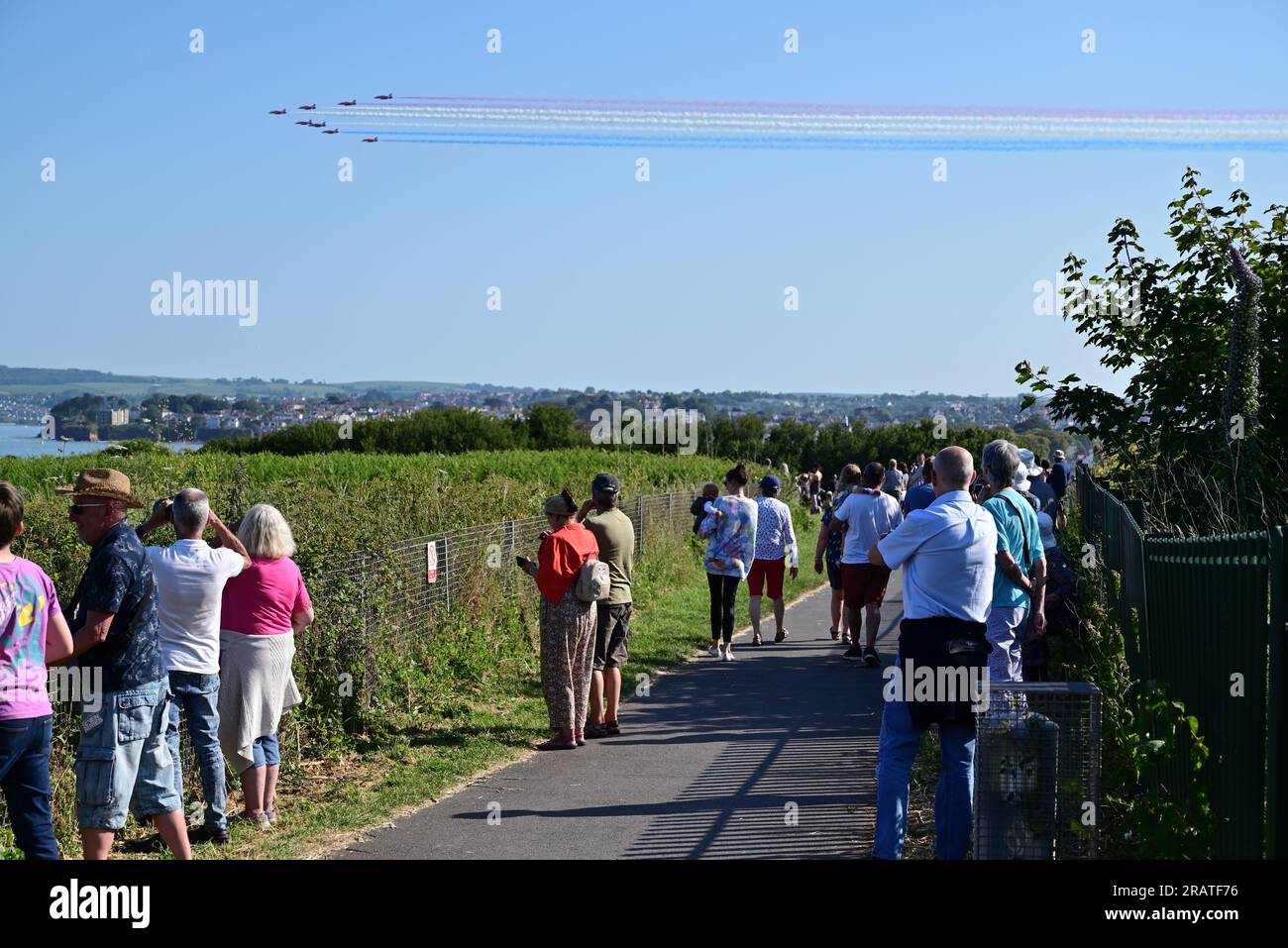 Während der englischen Riviera Airshow 2023 beobachten Menschen die roten Pfeile über Torbay. Stockfoto