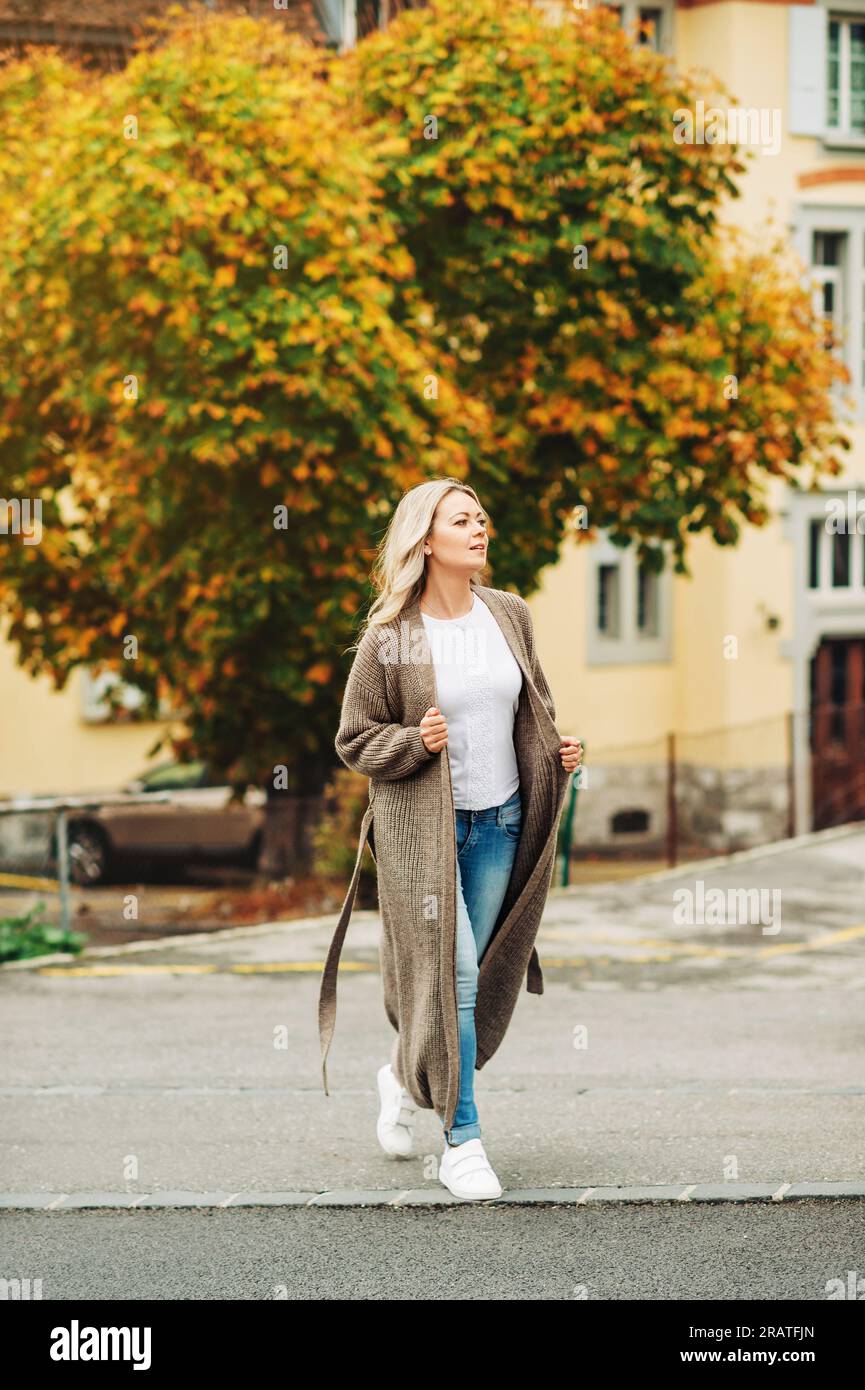 Außenporträt einer Modefrau mit langer beigefarbener Strickjacke Stockfoto