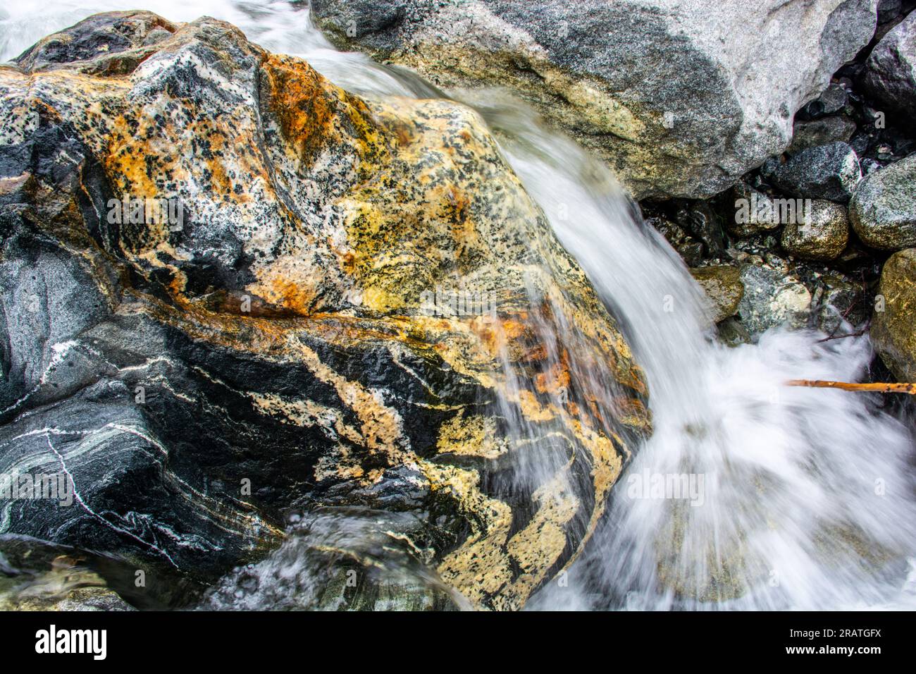 Gletscherwasser über einem Granitfelsen in der Provinz Xinjiang in China Stockfoto