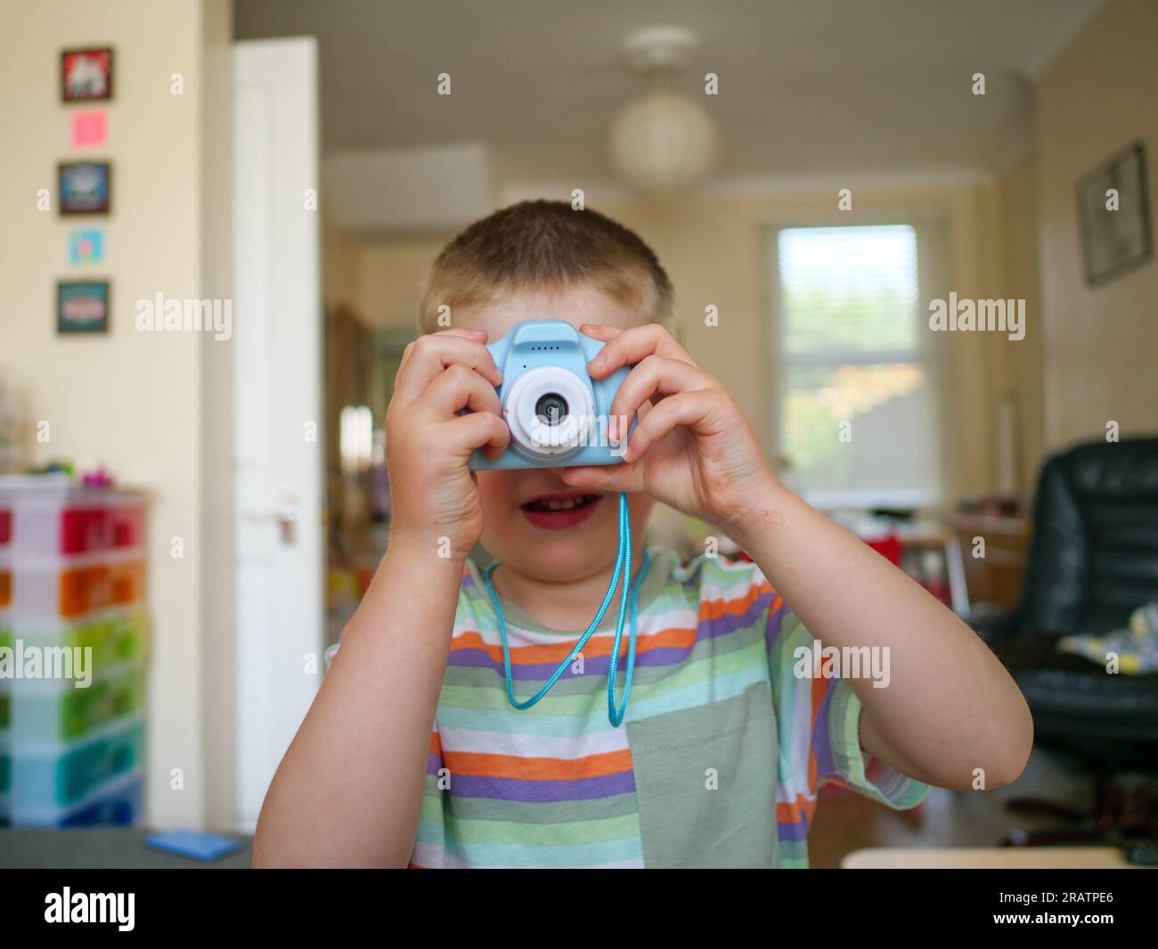 Kleines, vierjähriges Kind, das Fotos mit einer kleinen Plastikkamera macht Stockfoto