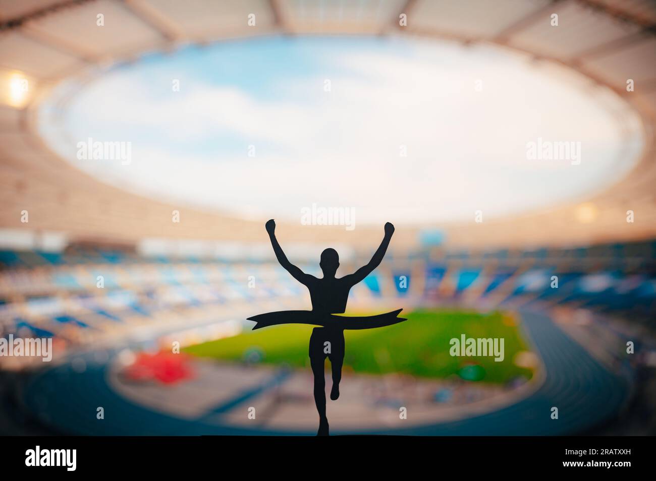 Champion's Triumph: Die Silhouette des Läufers erobert die Ziellinie im Modern Athletics Stadium. Wettbewerbsfoto für Bereich, Track und Feld bearbeiten. Stockfoto