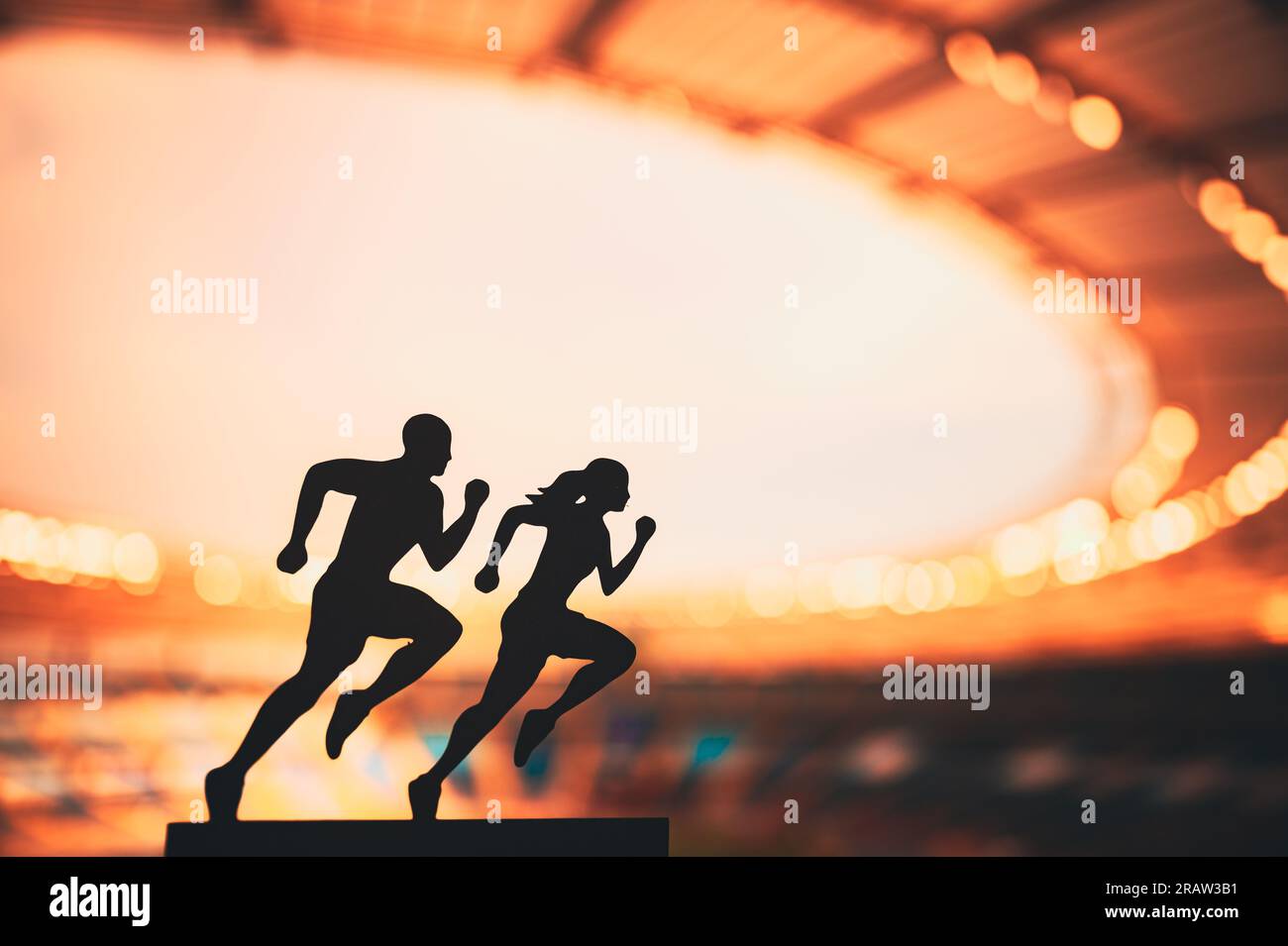 Gemeinsam nach Größe streben: Die Silhouetten männlicher und weiblicher Läufer setzen Grenzen und inspirieren sich gegenseitig in einem modernen Sportstadion. Stockfoto
