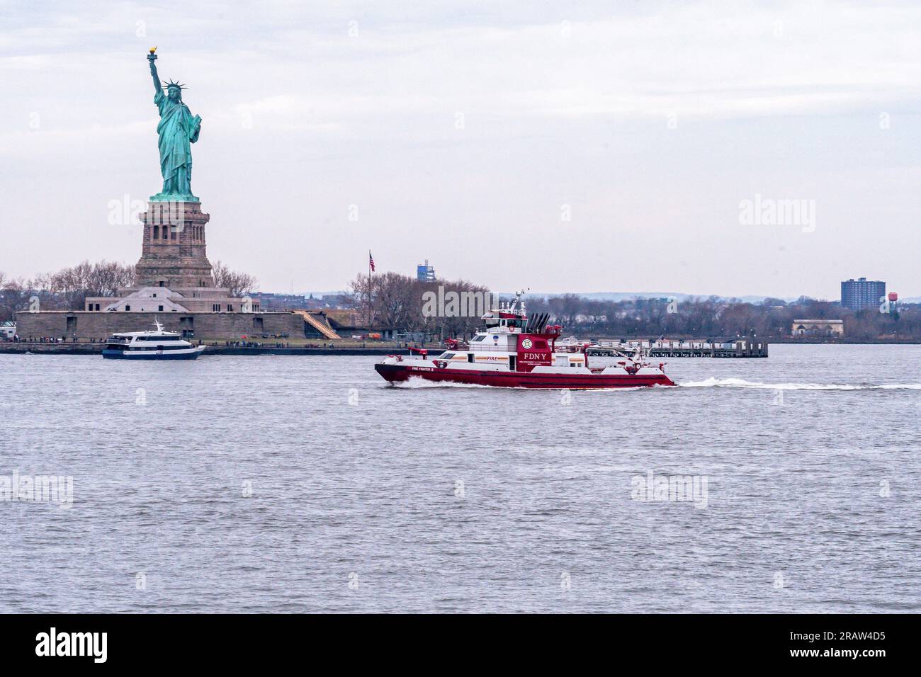 FDNY Feuerwehrboot vor der Freiheitsstatue im Hafen von New York Stockfoto