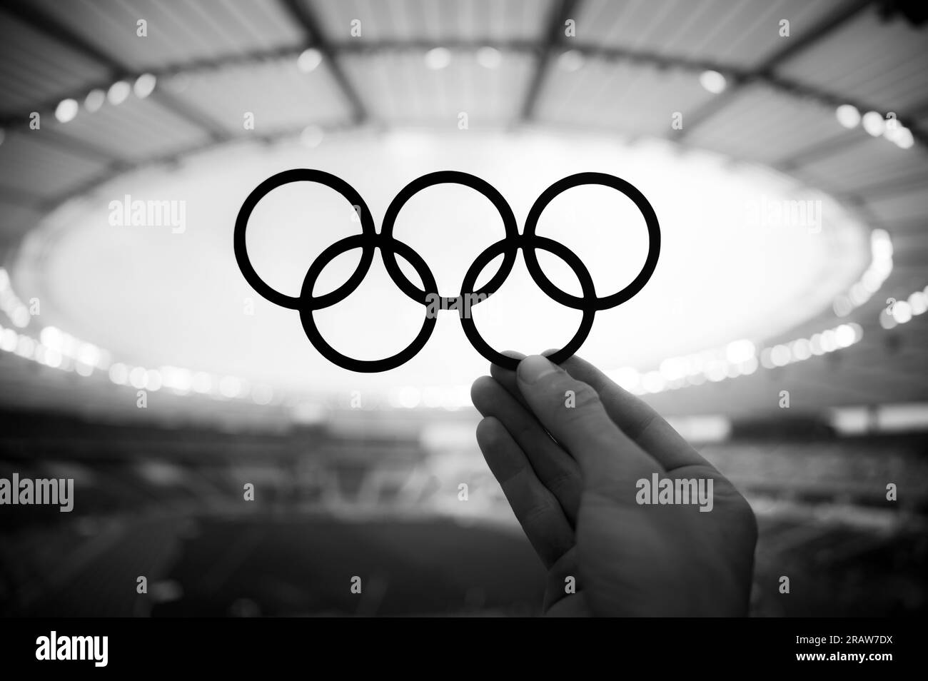 PARIS, FRANKREICH, 7. JULI 2023: Symbolischer Zusammenhang: Die Hand des Athleten trifft auf die Olympischen Ringe und spiegelt die Olympischen Sommerspiele in Paris 2024 wider Stockfoto