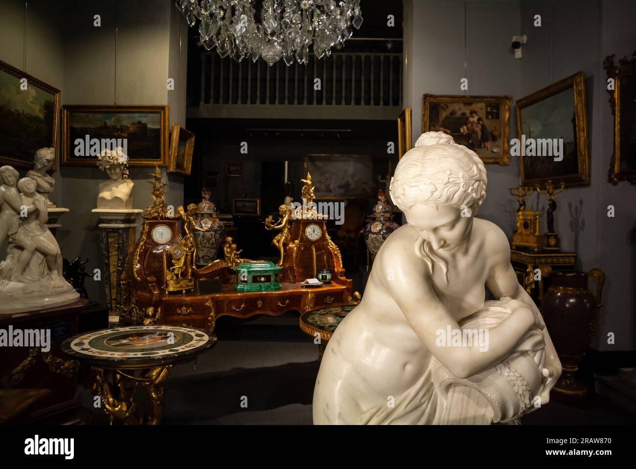Rom, Latium, Italien, ein Antiquitätengeschäft mit einer Marmorstatue, Gemälden und Tischen. Stockfoto