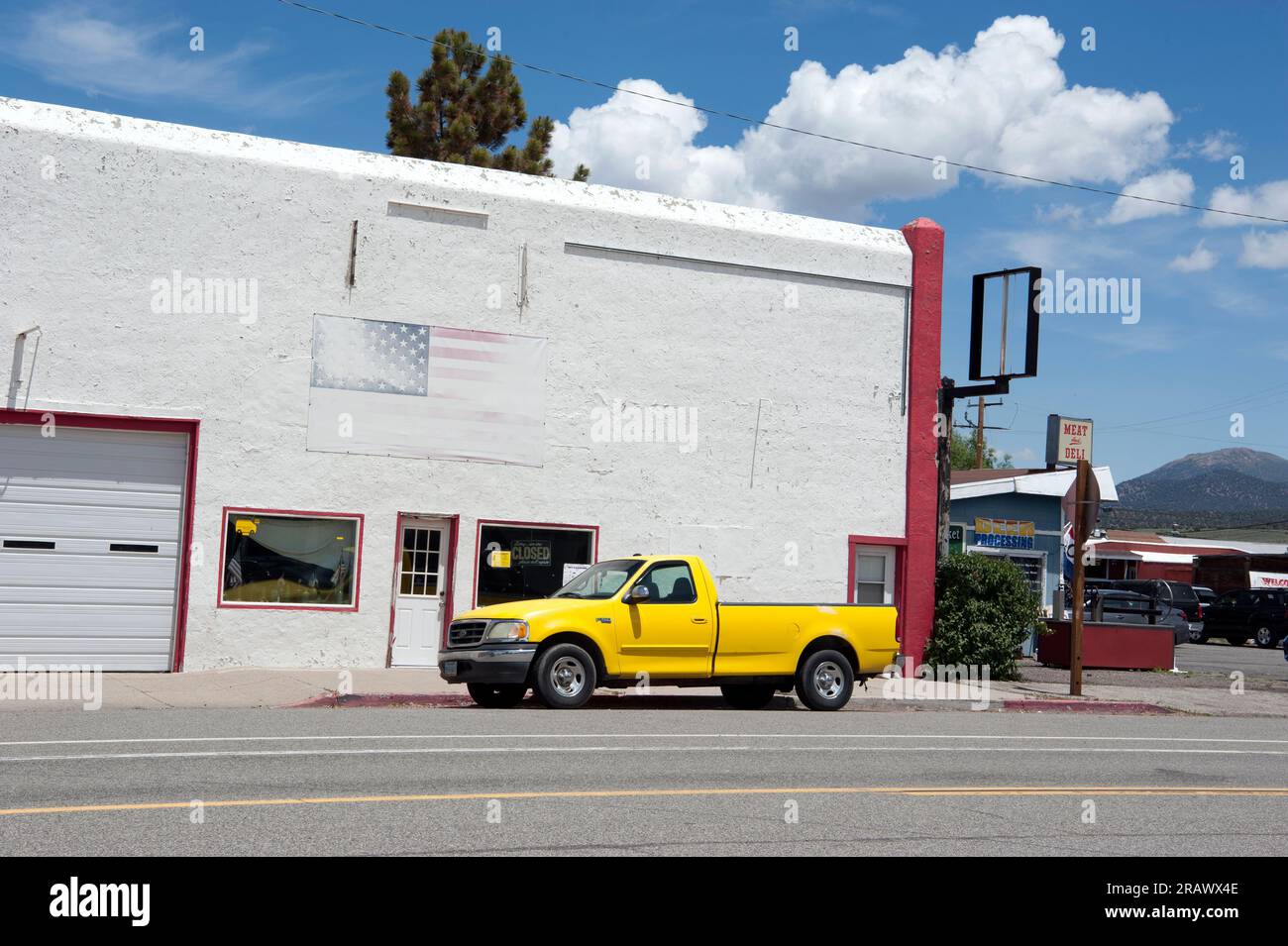 Ein großer gelber Pickup-Truck und eine verblasste US-Flagge auf der Main Street in Bridgeport, Kalifornien Stockfoto