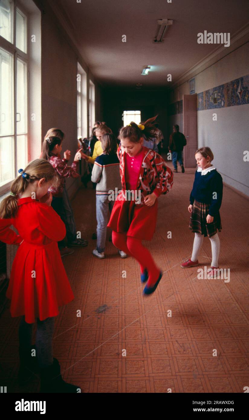 Pause an einer Mittelschule, Moskau, Russland, 1992. Mädchen der Mittelstufe, die im Spätherbst, weniger als ein Jahr nach dem Ende der Sowjetunion, in einem Schulflur einer öffentlichen russischen Mittelschule (Level 5-9) spielten. Stockfoto