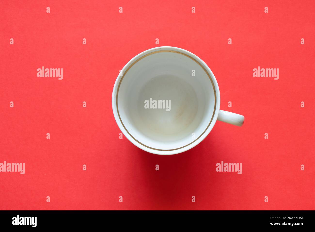 Alte Tasse mit roten Punkten auf einem farbigen roten Hintergrund – Nahaufnahme Stockfoto
