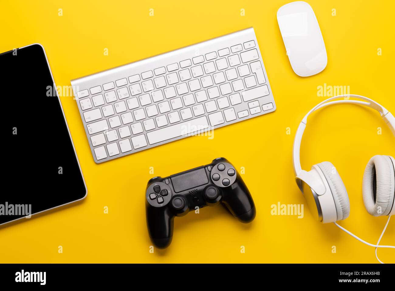Gaming-Ausrüstung und technisches Zubehör auf gelbem Hintergrund, perfekt für Spiele und technische Themen. Flach verlegt Stockfoto