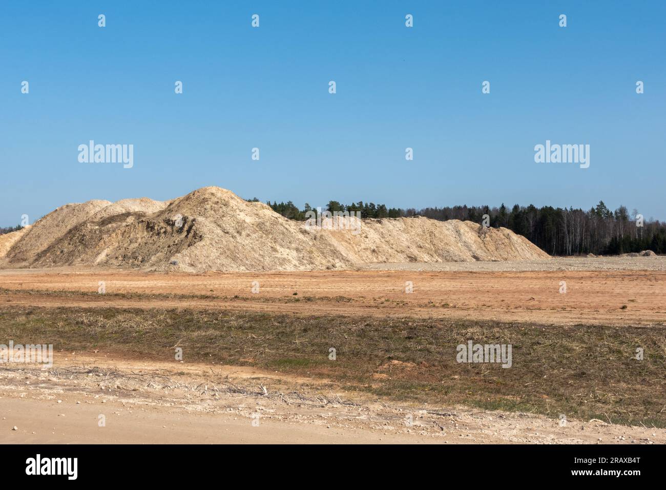 Ein riesiger Sandhaufen am blauen Himmel. Sandabbaugrube. Stockfoto