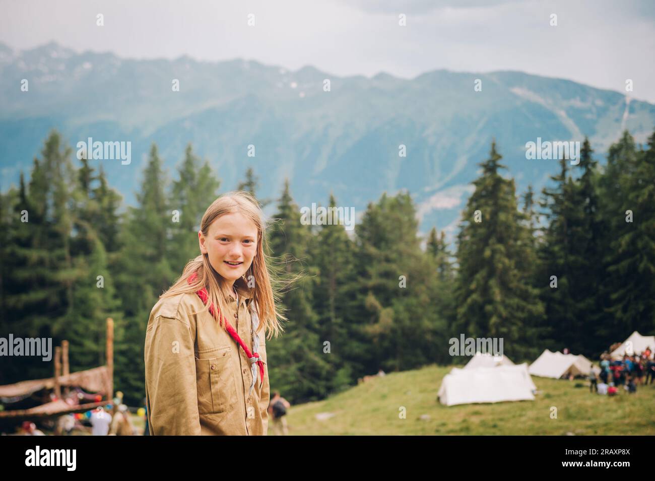 Glückliches kleines Pfadfindermädchen genießt Sommerlager in den Bergen Stockfoto