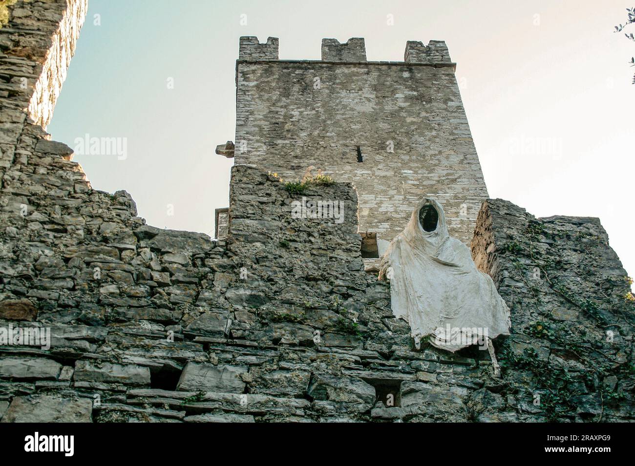 Perledo, Provinz Lecco, Region Lombardei, Ostküste des Comer Sees, Italien. Castello di Vezio. Die Burg stammt aus dem 11. Jahrhundert n. Chr. und überblickt und dominiert die Ostküste des Comer Sees. Im Gebäude befindet sich auch eine Falknerei. Die Burgmauern sehen Sie von innen mit einer typischen Gaze- und Gipsstatue, die einen Geist darstellt. Stockfoto