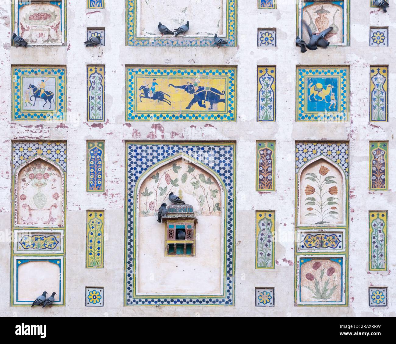 Details der farbenfrohen Bildmauer, erbaut vom mogul-Kaiser Jahangir in Lahore Fort, Punjab, Pakistan, mit wunderschönen Gemälden, Mosaiken und Tauben Stockfoto