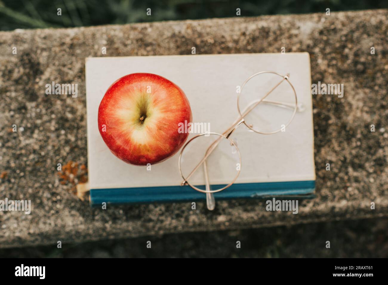 Retro-Stil mit altem Buch, Vintage-Brille und rotem Apfel, Bildungskonzept Stockfoto