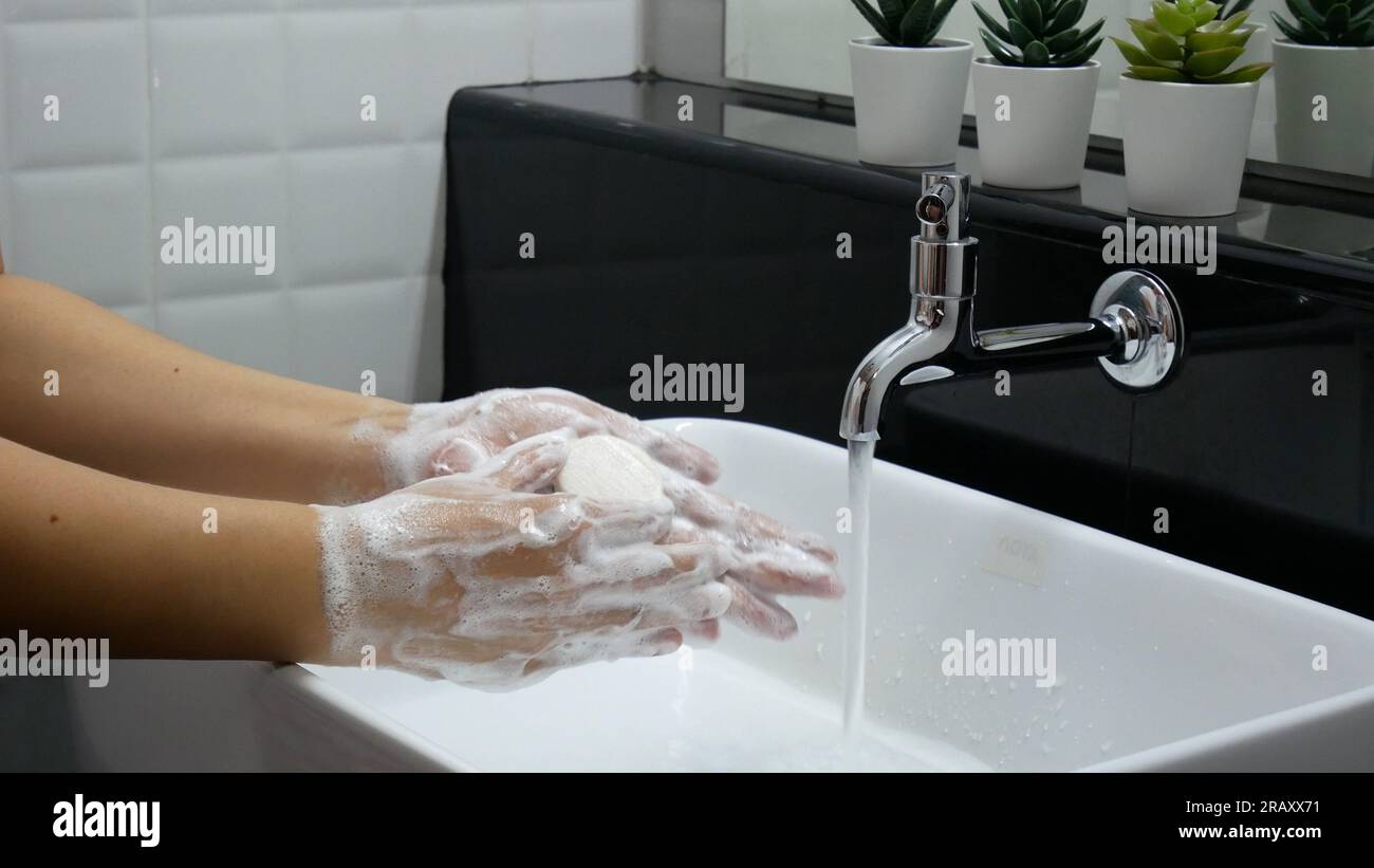 Körperhygiene. Hände waschen, Hand gründlich mit Seife reiben, die viele Blasen für die Reinigung und Desinfektion am Waschbecken im Badezimmer hat. Stockfoto
