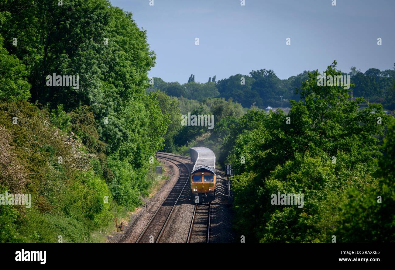 GB Eisenbahnfrachtzug der Klasse 66, der auf Gleisen in Warwickshire, England, verkehrt. Stockfoto