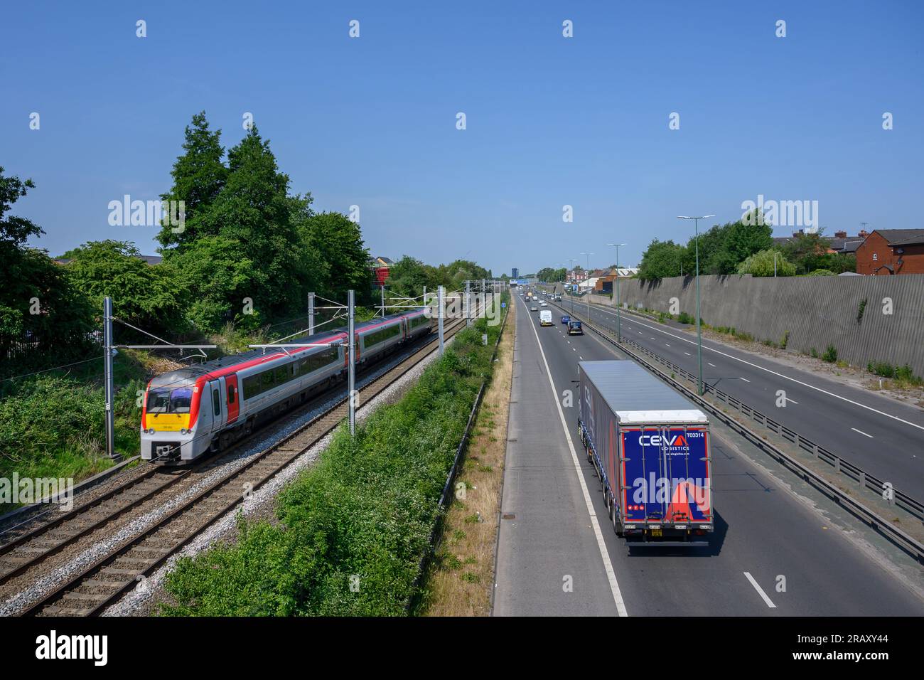 Transport für Wales Zug auf Gleisen entlang einer Straße in Salford, England. Stockfoto