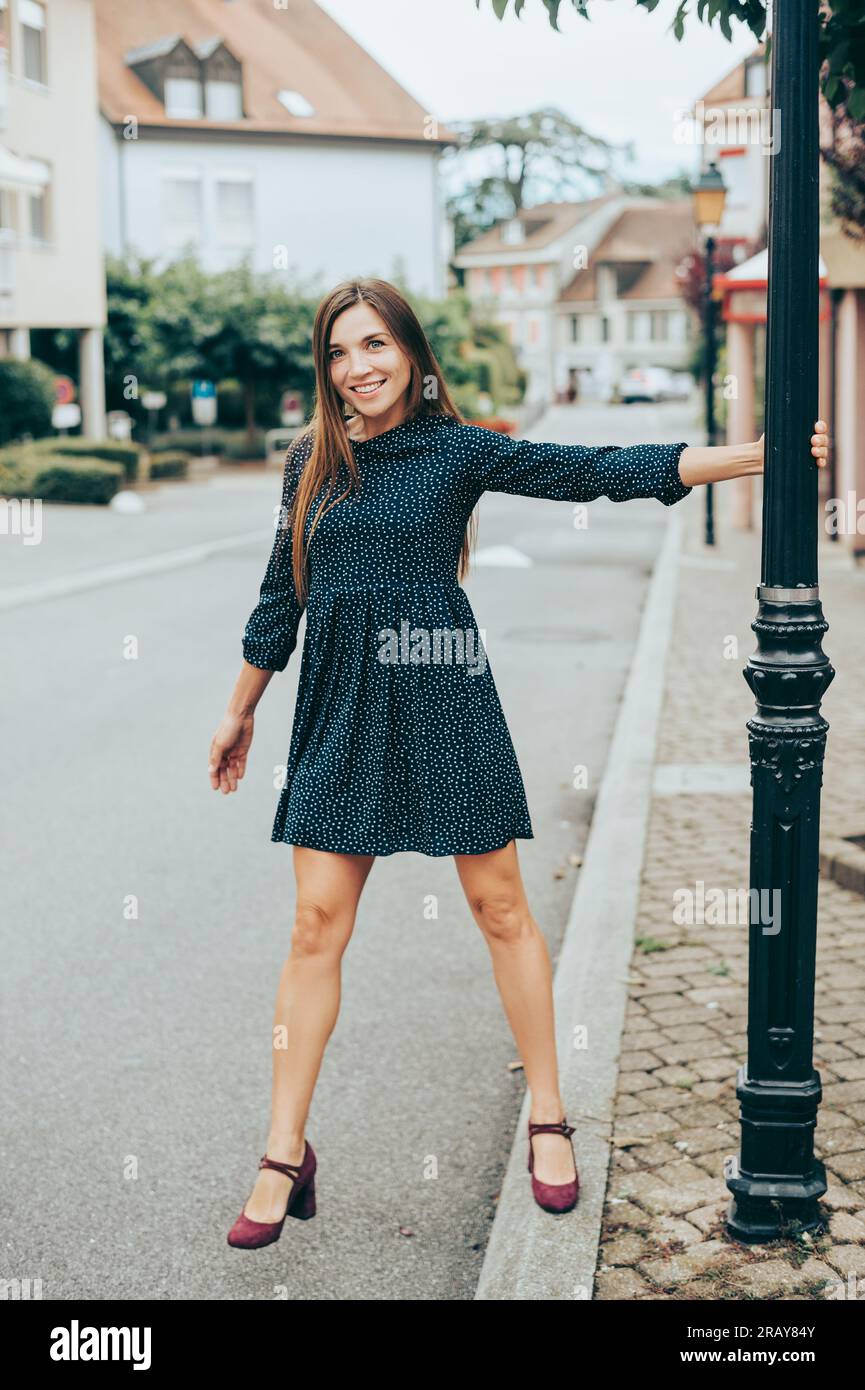Außenporträt einer glücklichen, schönen Frau, die ein Minikleid trägt Stockfoto
