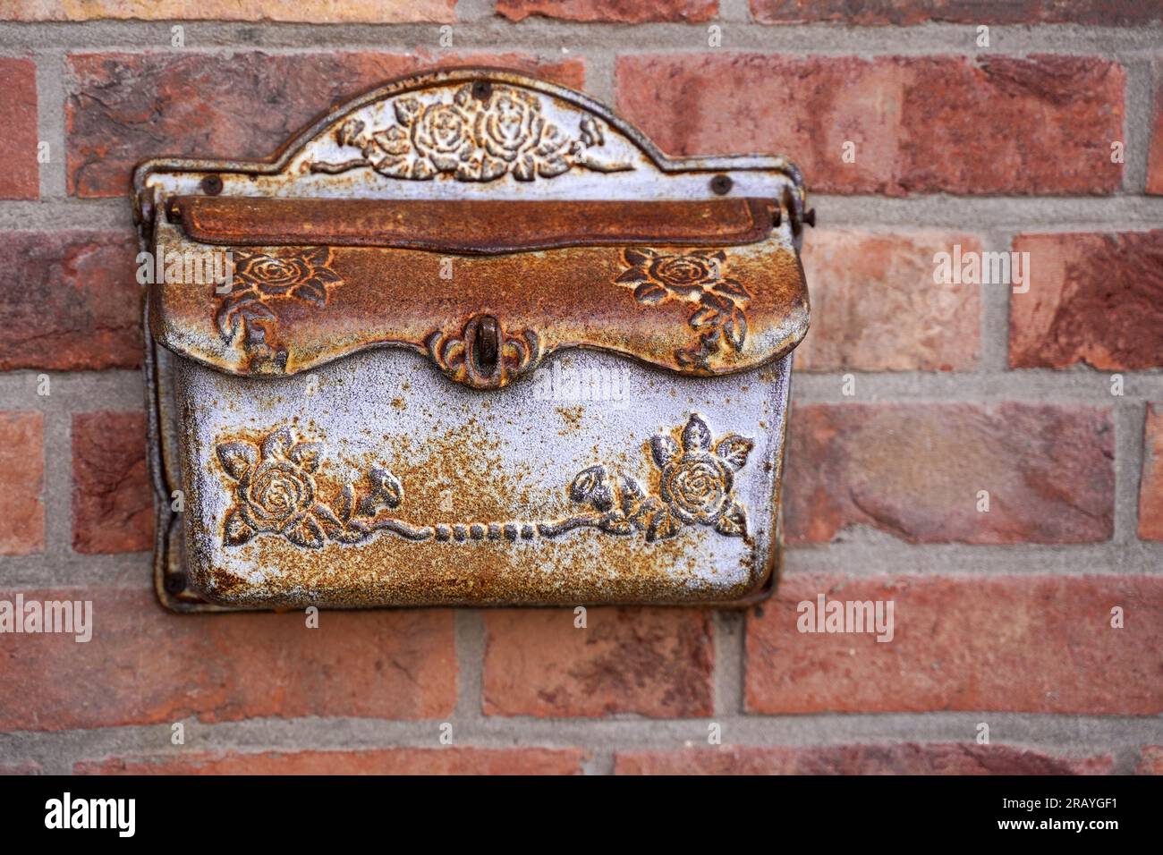 Ein alter eiserner Briefkasten an einer Ziegelwand. Stockfoto
