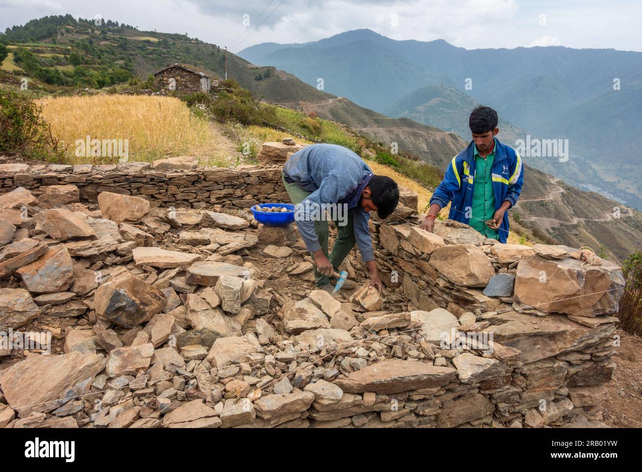 Juni 28. 2023, Nagthat, Uttarakhand, Indien. Einheimische Arbeiter bauen ein traditionelles Haus mit Stein in einem Dorf auf dem Land. Himalaya-Region UTT Stockfoto