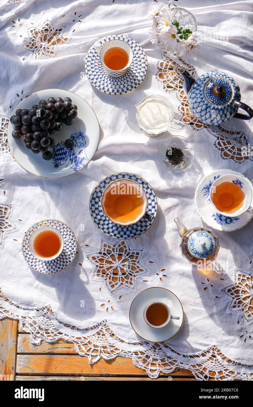 Tee auf einer weißen Tischdecke im Sommersonnenschein Stockfoto