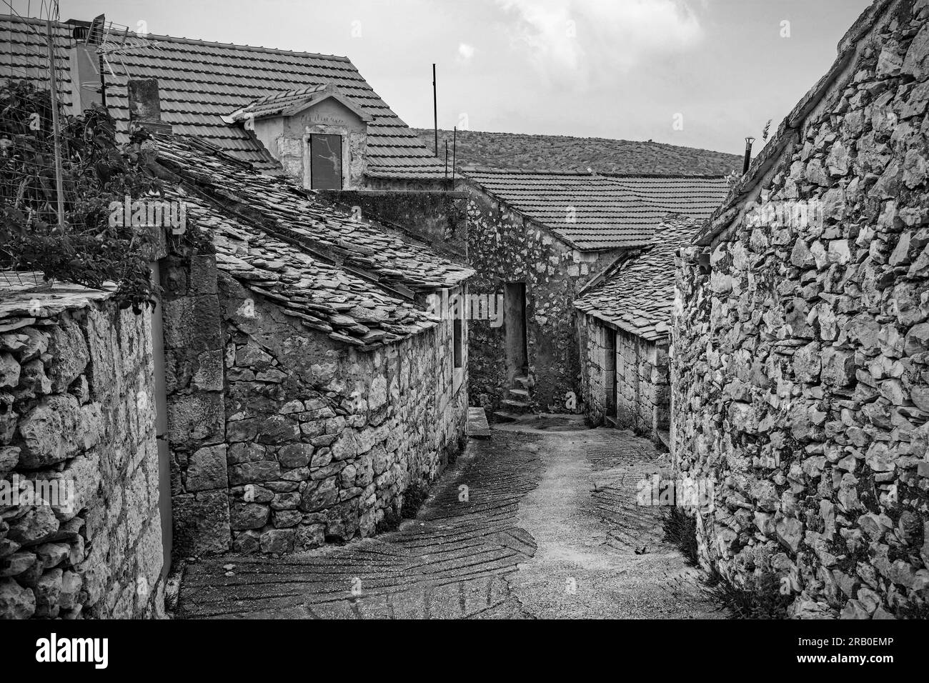 Eine Straße mit historischen Steinhäusern im Dorf Loziscz im Zentrum der Insel Brac in Kroatien Stockfoto