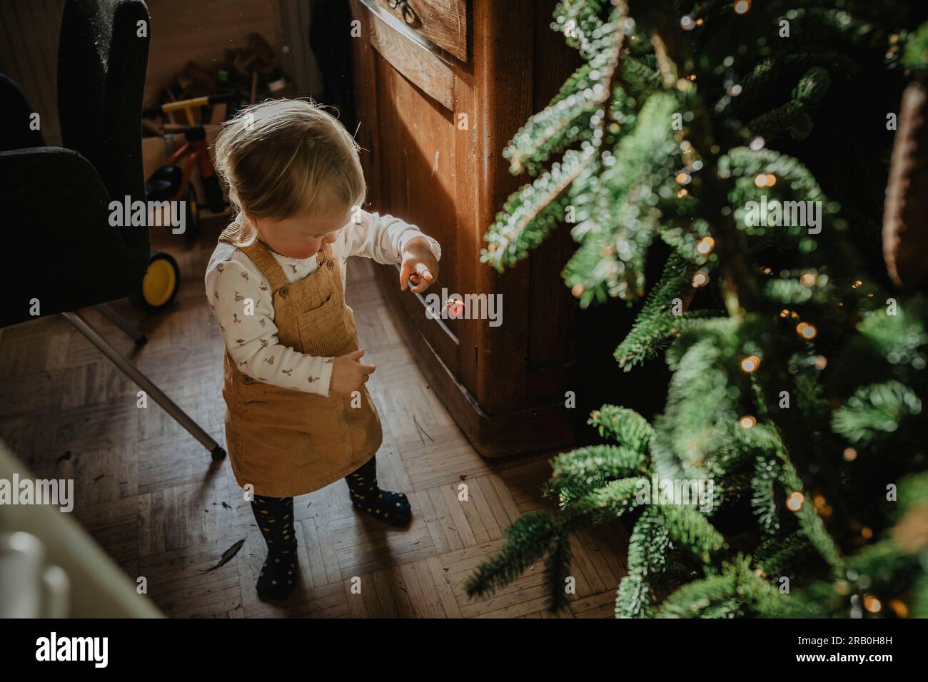 Das kleine Mädchen hilft beim Dekorieren des Weihnachtsbaums Stockfoto