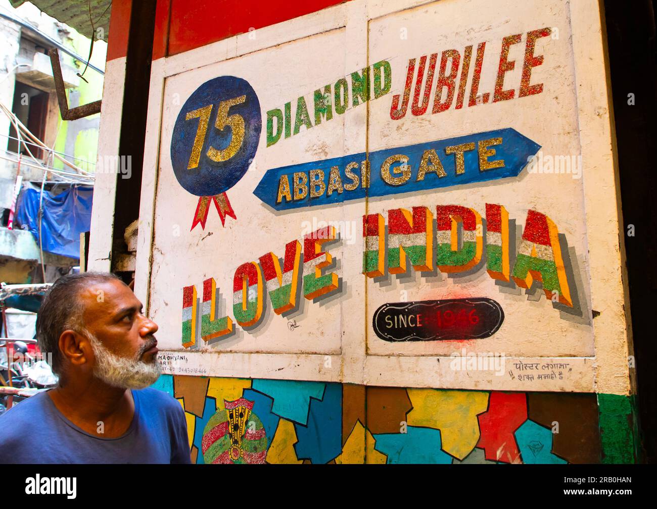 Ein indischer Mann, der auf eine Plakatwand für das Diamantenjubiläum schaut, Delhi, Neu-Delhi, Indien Stockfoto