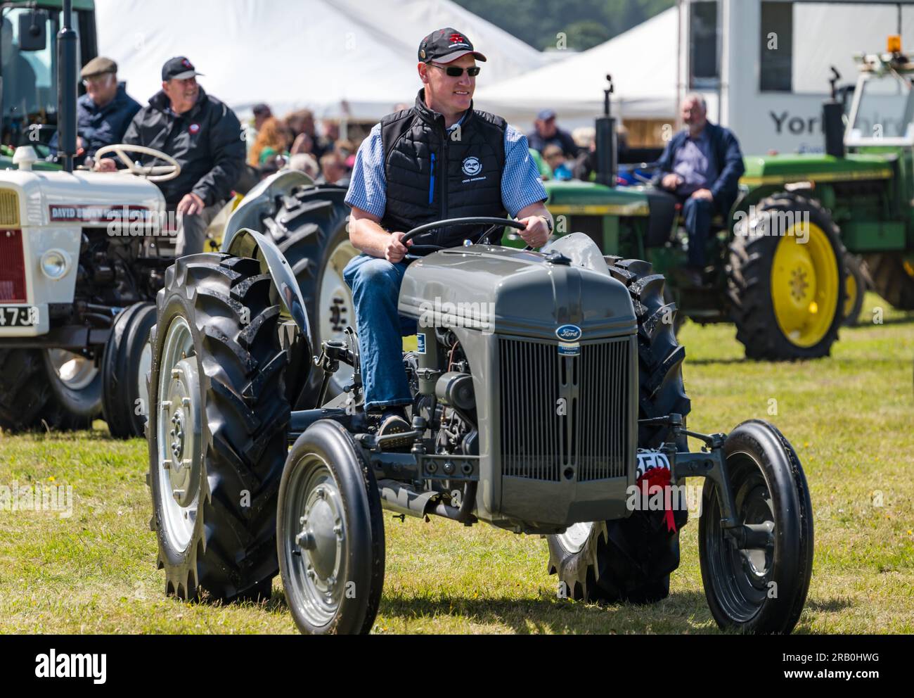 Ein Mann fährt einen alten Ford-Traktor auf der Haddington Agricultural Show, East Lothian, Schottland, Großbritannien Stockfoto