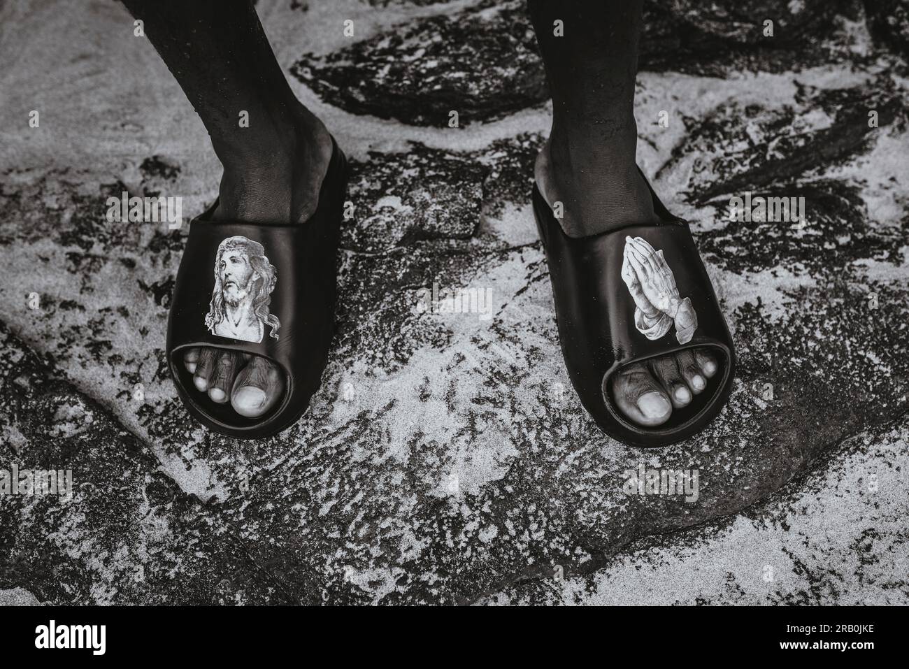 Detailaufnahme der Füße in Badeschuhen am Strand Stockfoto