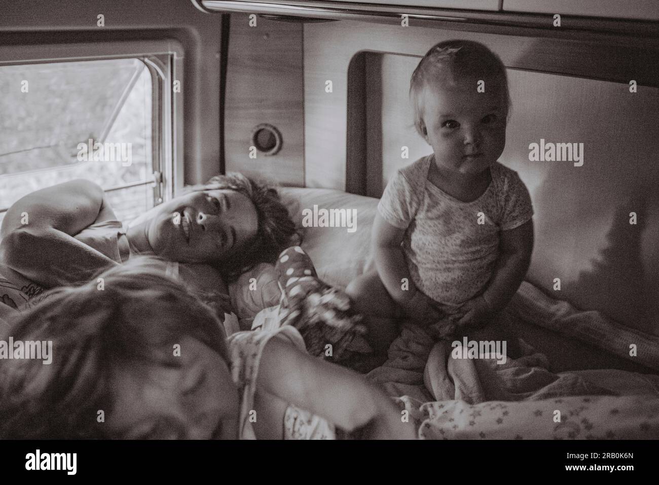 Mutter liegt mit ihren Kindern im Bett vom Wohnmobil aus Stockfoto