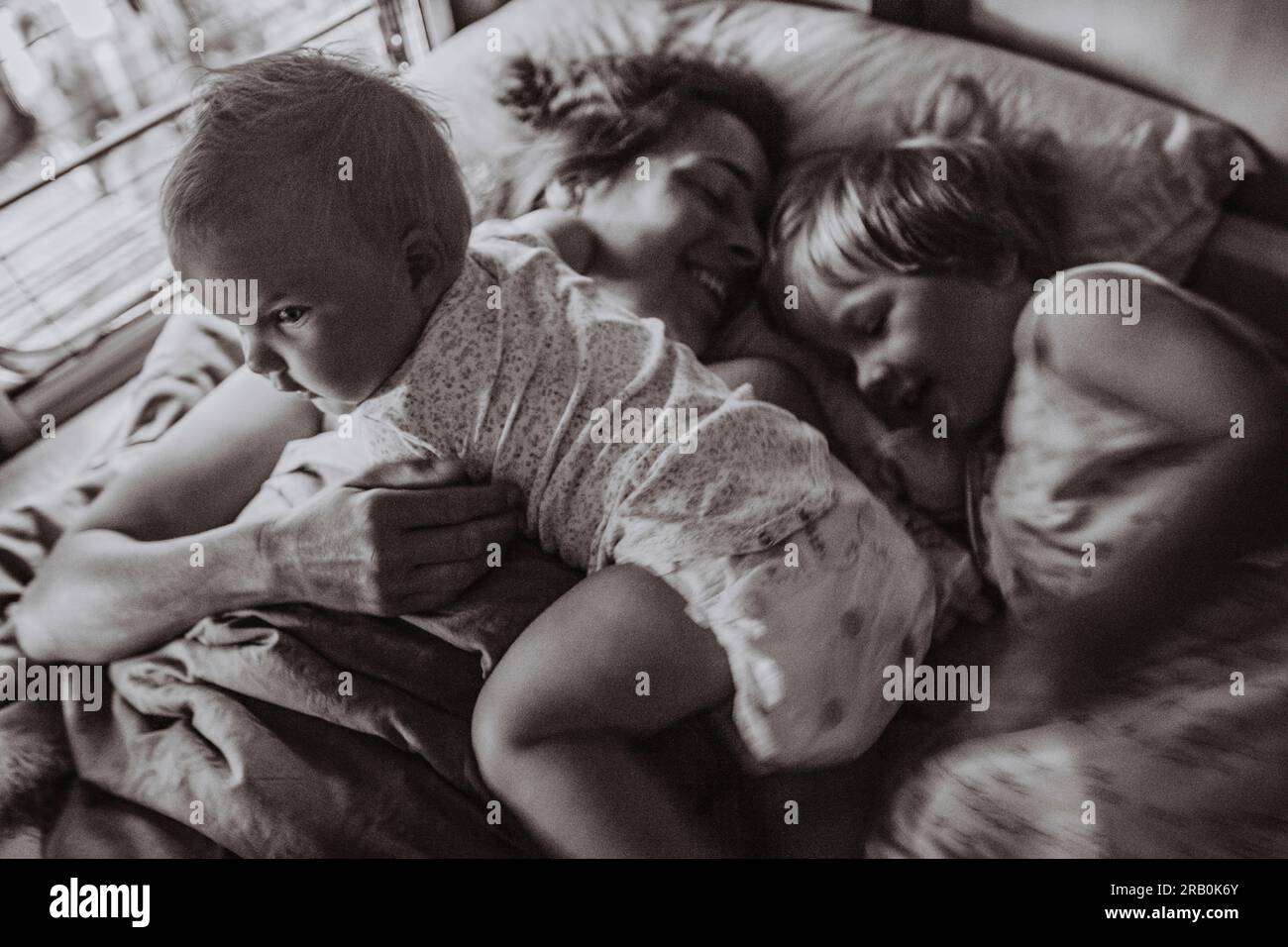 Mutter liegt mit ihren Kindern im Bett vom Wohnmobil aus Stockfoto