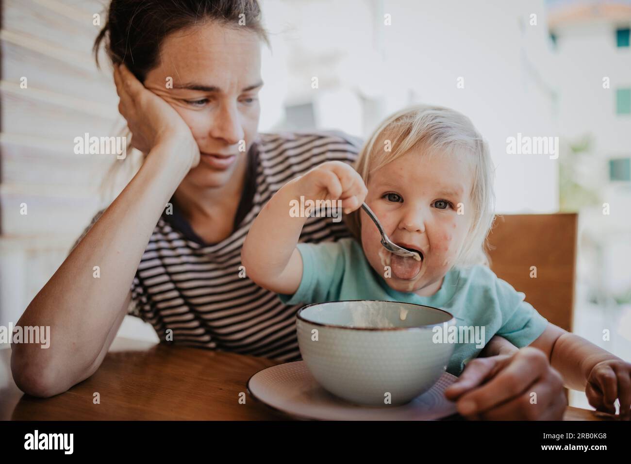 Mutter und Tochter sitzen vor dem Tisch und essen Stockfoto