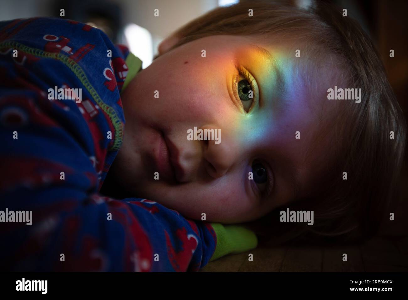 Regenbogenfarben reflektieren das Gesicht des Jungen Stockfoto