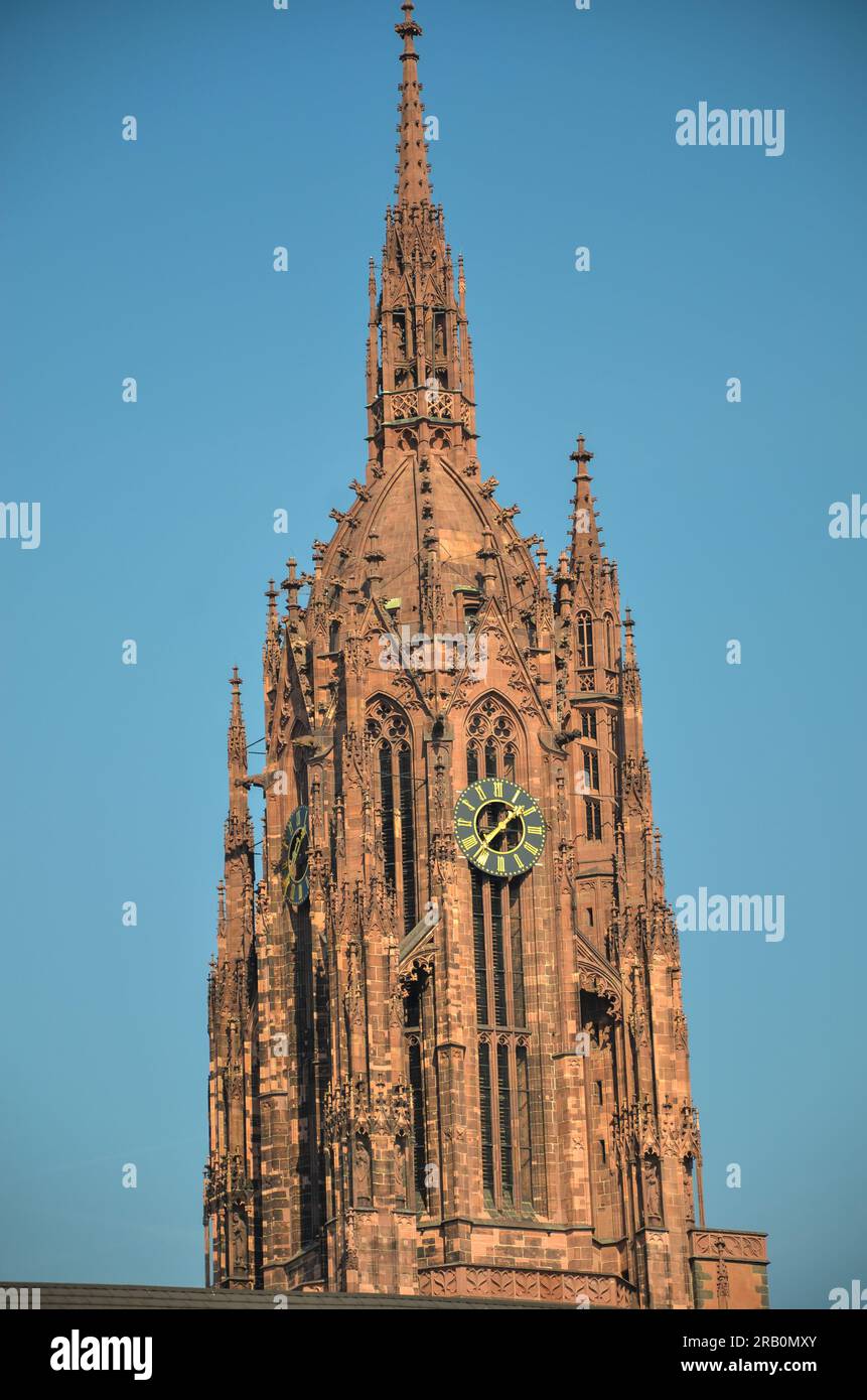 Roter Turm mit großer Uhr der kaiserlichen Kathedrale St. Bartholomäus in Frankfurt am Main unter blauem Himmel Stockfoto