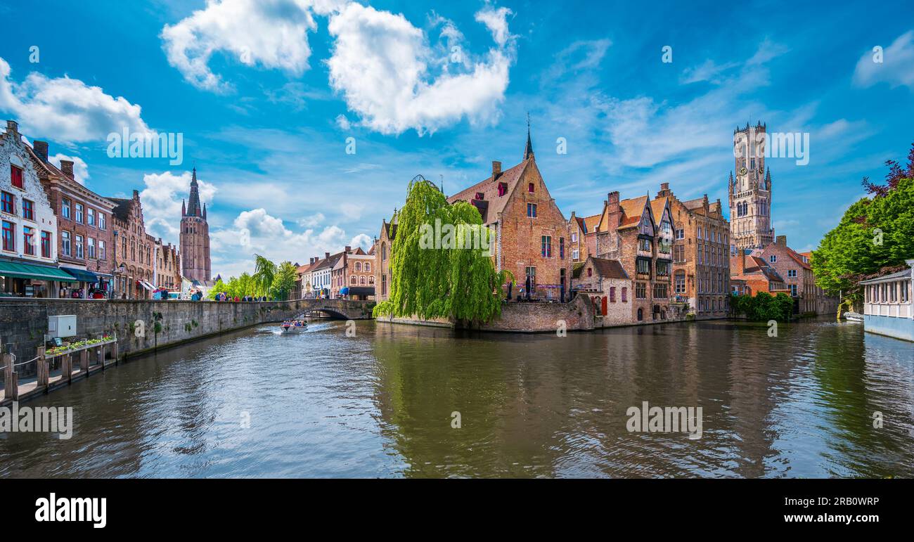 Historische Gebäude entlang eines Kanals und des Belfort-Turms in Brügge, Belgien Stockfoto
