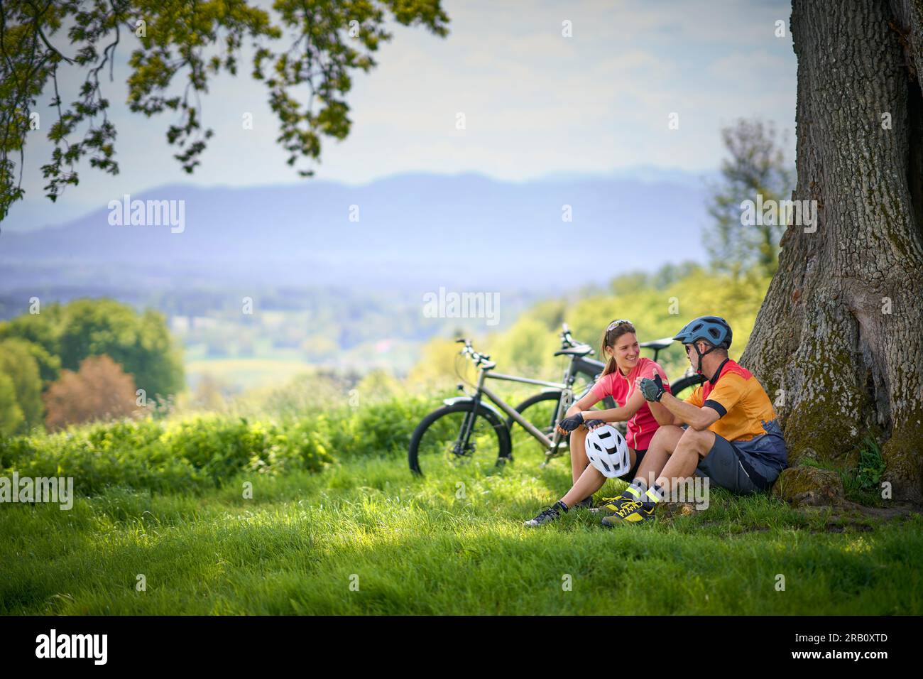 Ein Paar, Mann und Frau, die mit Fahrrädern unterwegs sind, sich ausruhen, ausruhen, Trekking, E-Bike Stockfoto