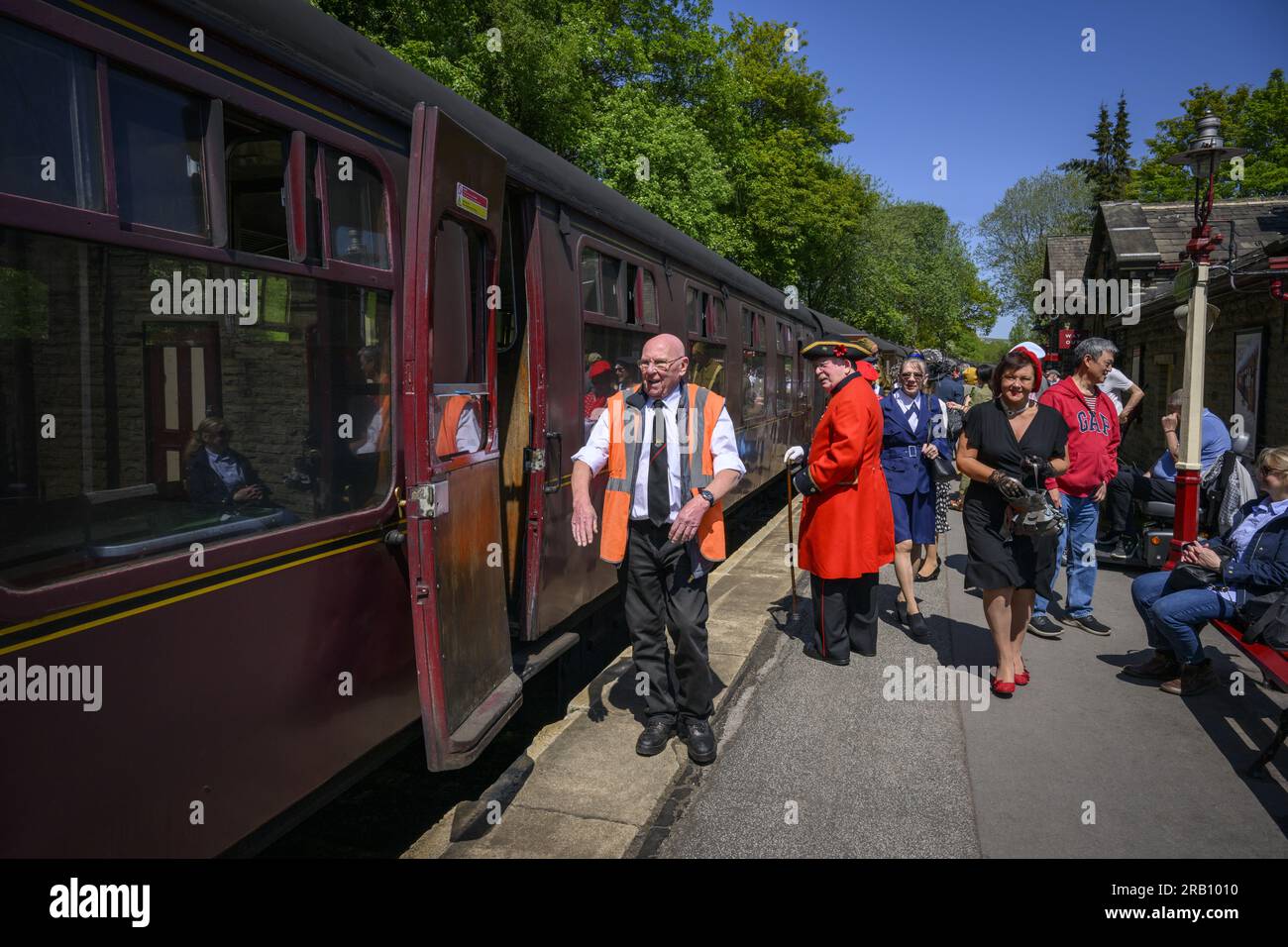 Nachstellung der WW2 Jahre (Retro-Kleidung, altes rollendes Material, historische stationäre Kutsche) – Haworth Station, West Yorkshire, England, Großbritannien. Stockfoto