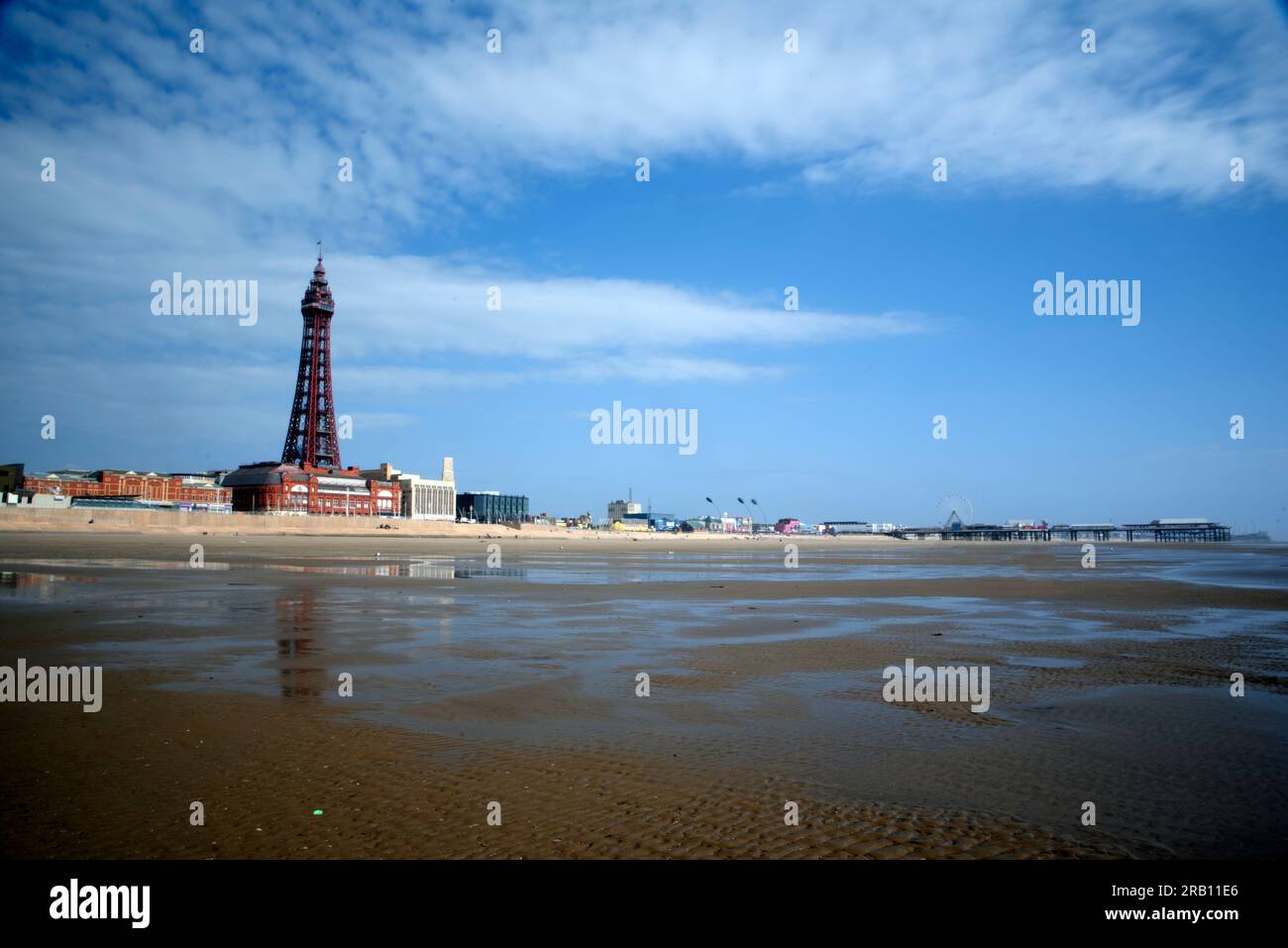 Der Sandstrand von Blackpool zeigt den Blackpool Tower mit Central Pier in der Ferne. Stockfoto