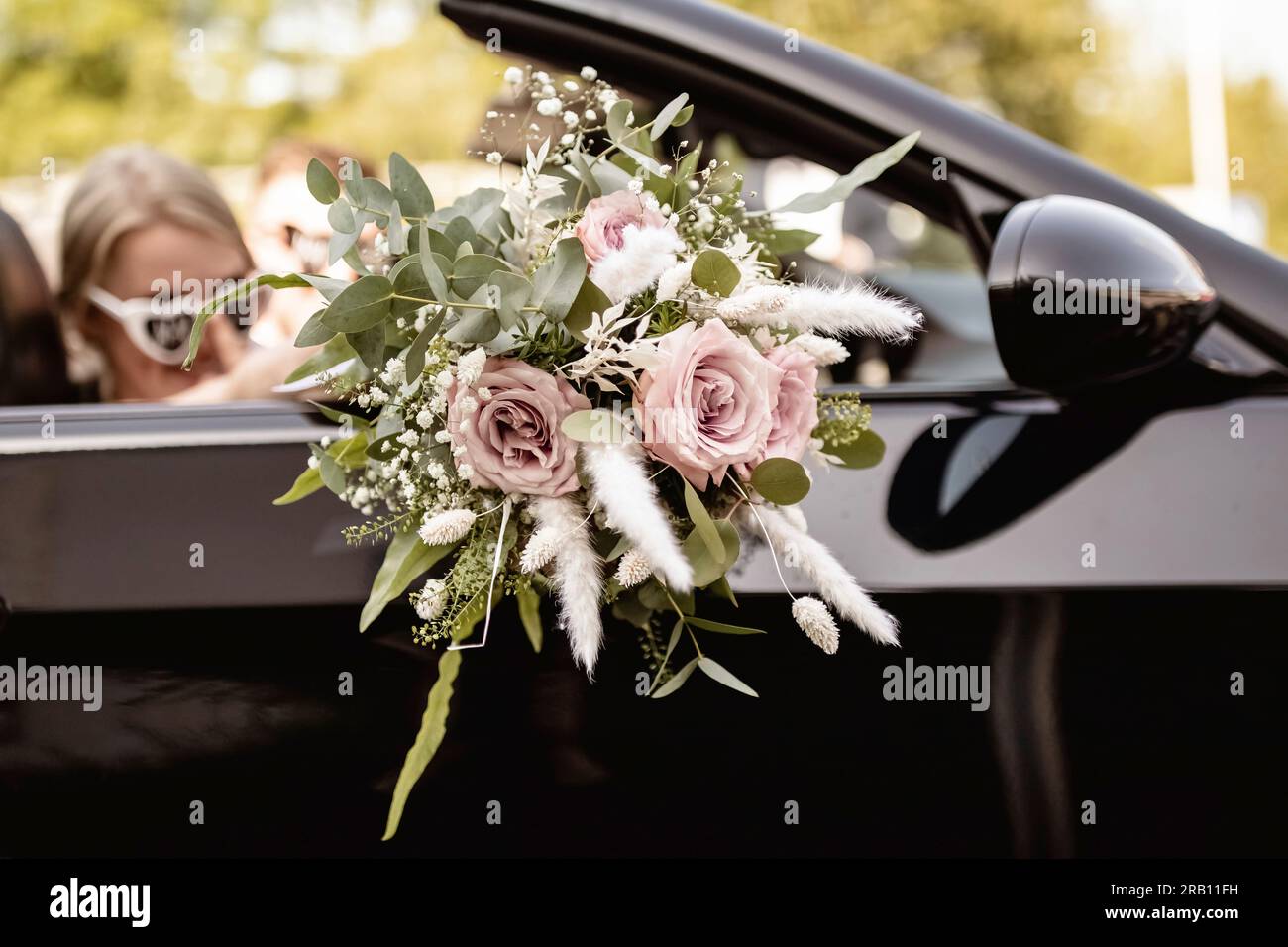 Fotoshooting nach der Hochzeitszeremonie mit Brautstrauß und Cabrio. Stockfoto