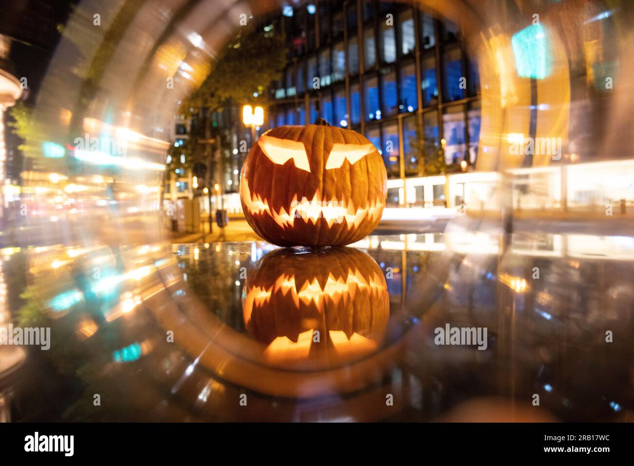 Spül-Maske, Halloween mit Kürbis. LED-Maske, gruseliger Mann. Corona, witzig, oktober, draußen. Urbane Szene Stockfoto