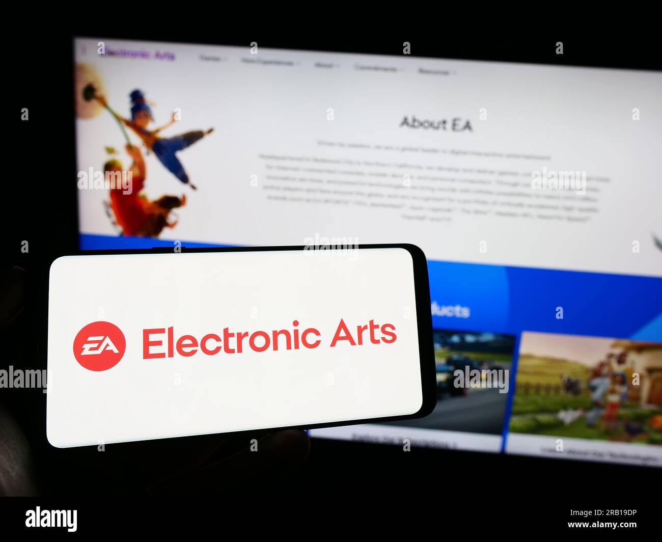 Person, die ein Mobiltelefon mit dem Logo des Videospielunternehmens Electronic Arts Inc. Besitzt (EA) auf dem Bildschirm vor der Webseite. Konzentrieren Sie sich auf das Display des Telefons. Stockfoto