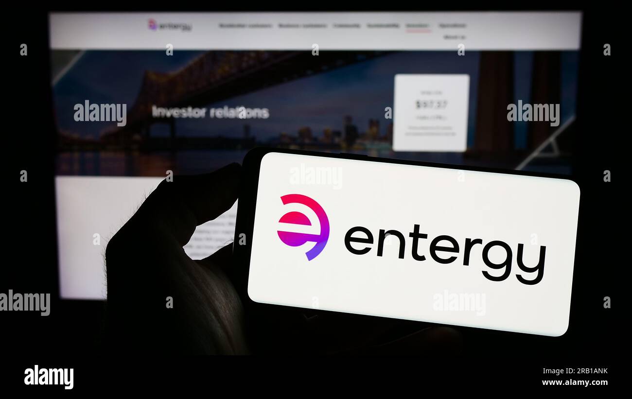 Person, die ein Mobiltelefon mit dem Logo des US-amerikanischen Energieunternehmens Entergy Corporation auf dem Bildschirm vor der Unternehmenswebseite hält. Konzentrieren Sie sich auf das Display des Telefons. Stockfoto