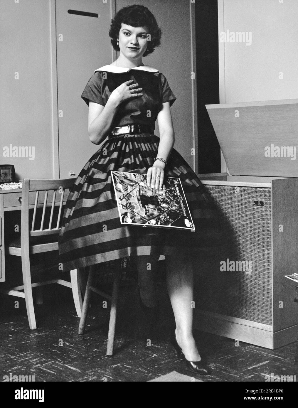 Vereinigte Staaten: c. 1952 Eine junge Frau, die sich das Plattenalbum Greensleeves des Montovani Orchestra bewusst anhört. Stockfoto