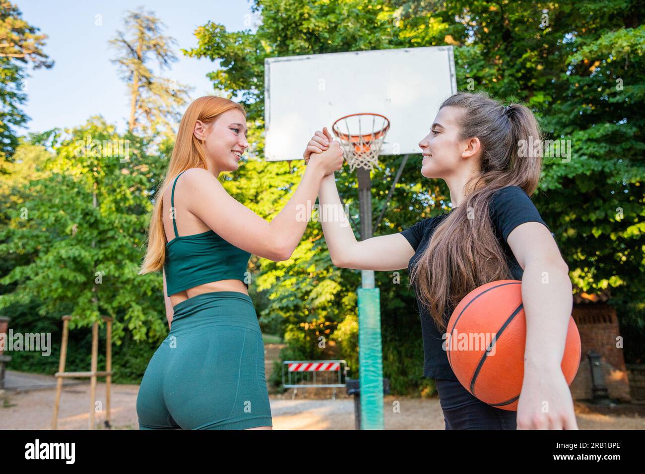 Zwei Basketballspieler schütteln sich während eines Basketballspiels die Hand, Fairness und Respekt Stockfoto