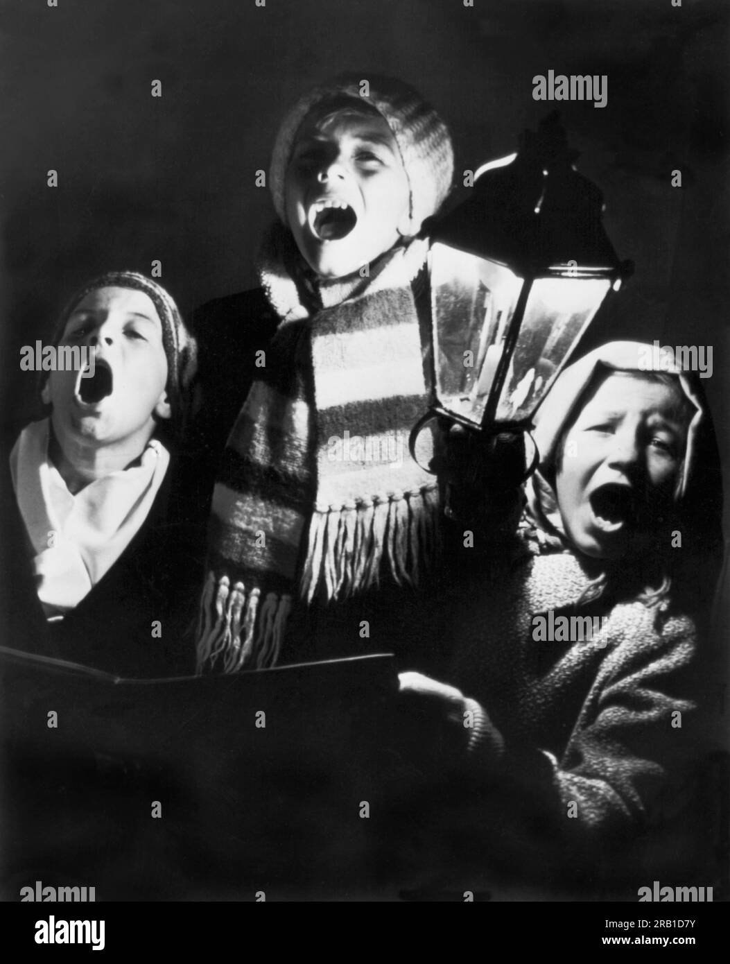 San Jose, Kalifornien: 24. Dezember 1942 drei Waisen aus dem Heim der Benevolence in San Jose begrüßen die Weihnachtszeit mit fröhlichen Weihnachtsliedern. Stockfoto