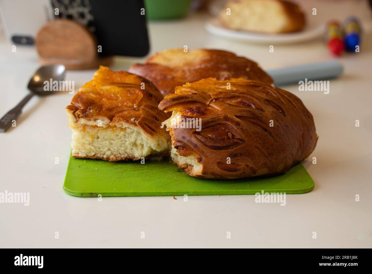 Hausgemachtes Brötchen liegt morgen früh auf einem grünen Brett auf dem Küchentisch Stockfoto