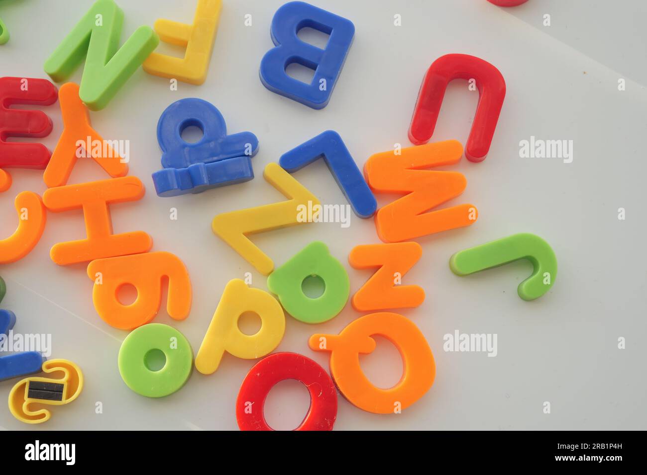 Bunte Plastikbuchstaben auf weißem Hintergrund, Nahaufnahme Stockfoto