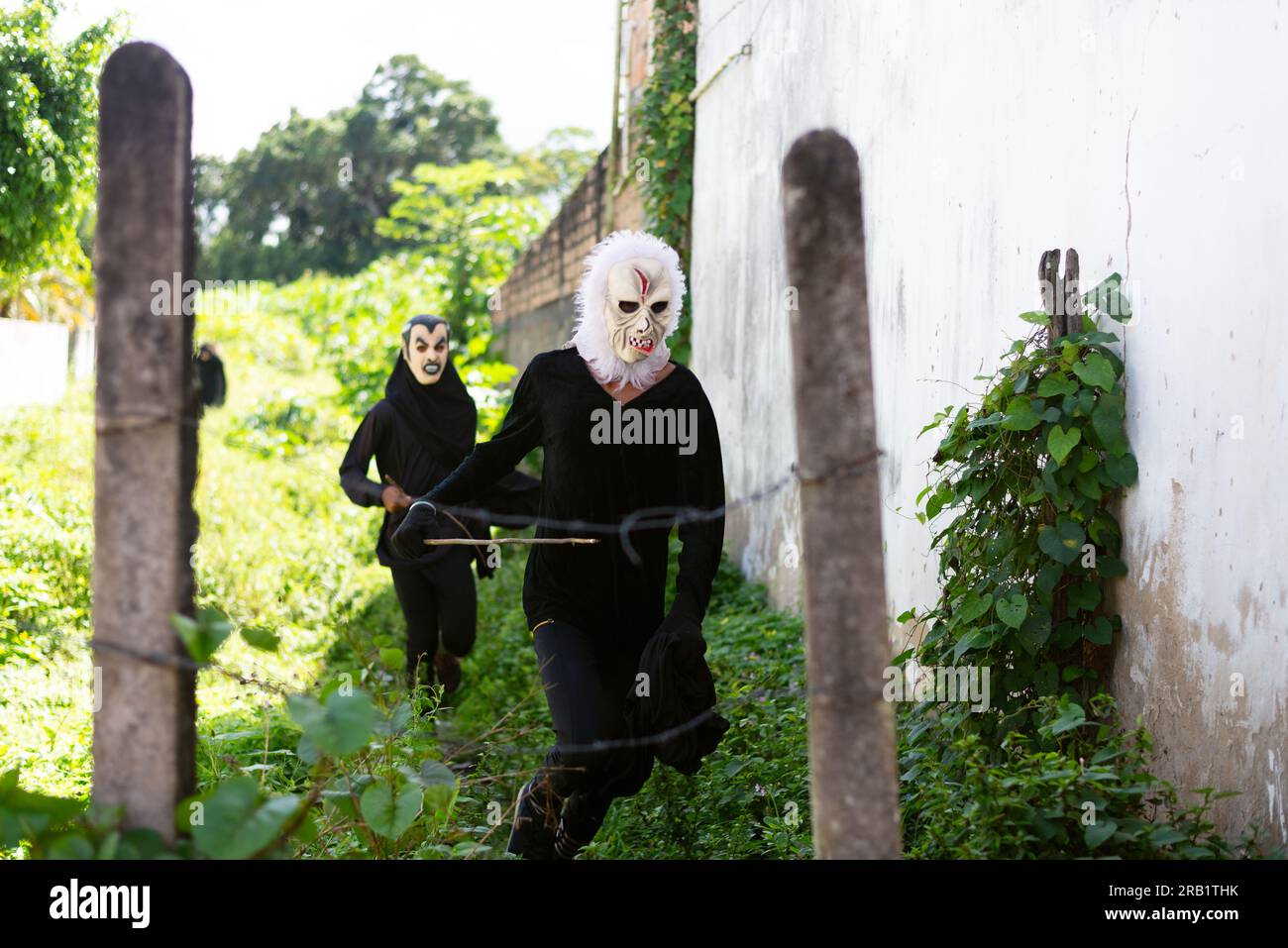 Santo Amaro, Bahia, Brasilien - 24. Juli 2022: Während einer kulturellen Demonstration in Acupe in den CI werden zwei Personen in Schwarz mit einer Terrormaske gesehen Stockfoto
